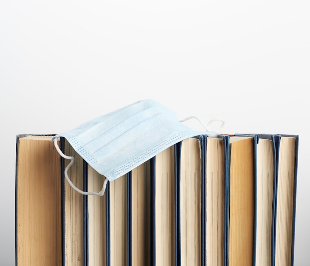 Stack of various books and disposable medical masks