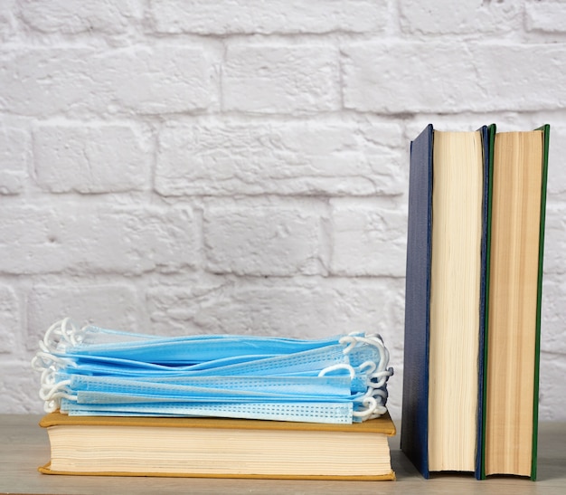 Stack of various books and disposable medical masks