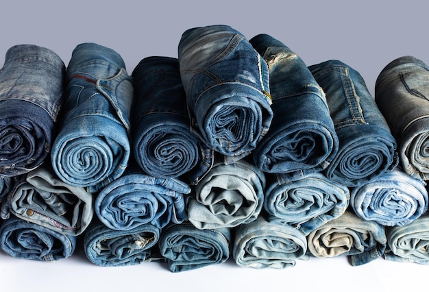 Stack of various shades blue jeans Jeans stacked isolated on white background Blue denim jeans texture banner with copy space for text design background Canvas denim fashion texture