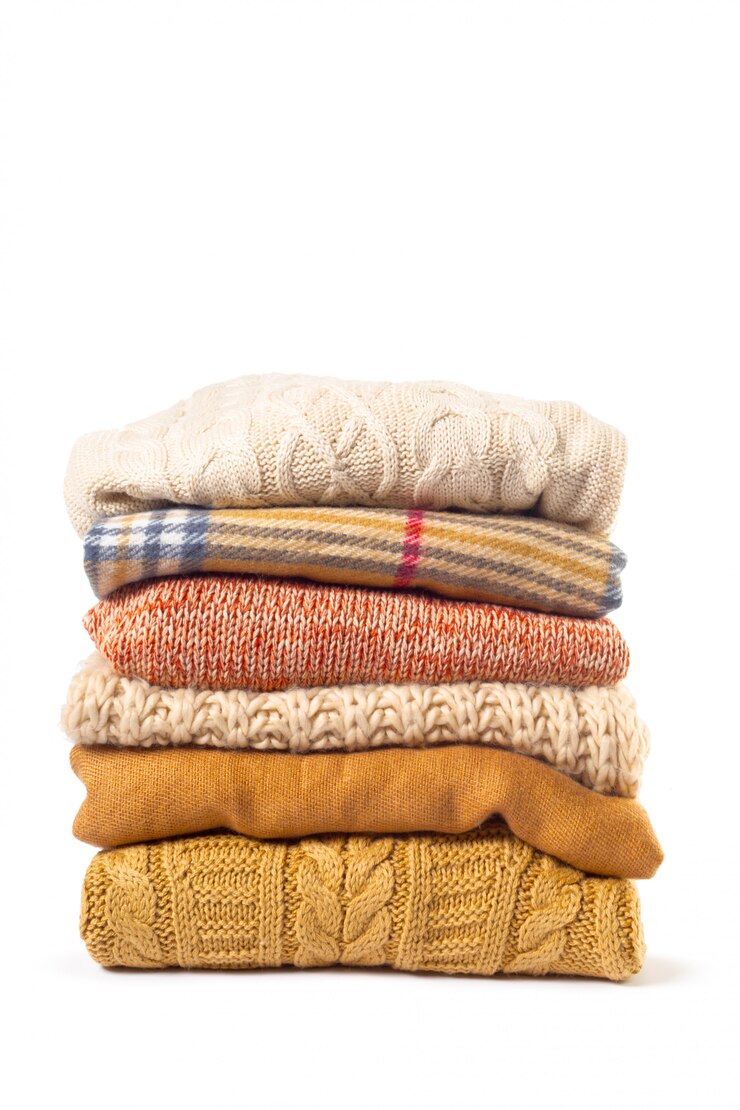 Photo stack of various sweaters isolated on white 