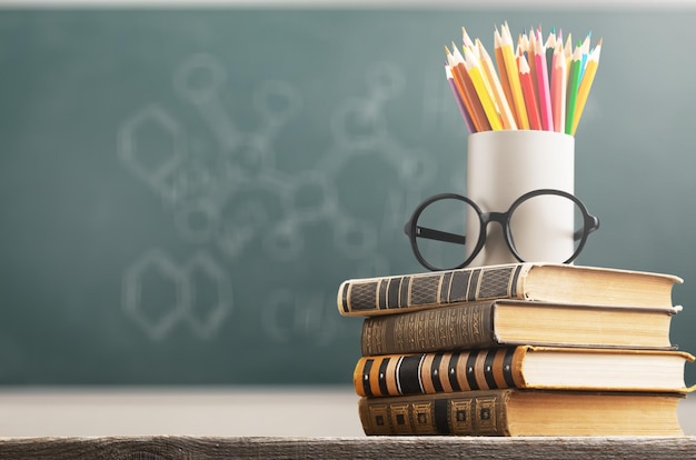 Stack of vintage books, eyeglasses and pencils, education and learning