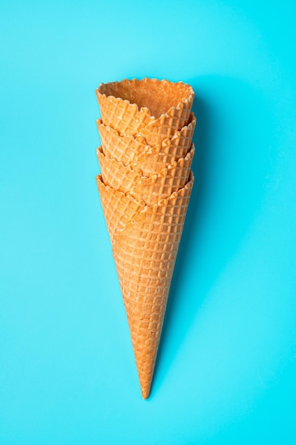 A stack of waffle cones for ice cream on a blue background