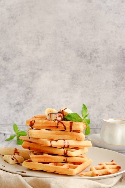 Stack of waffles with banana and chocolate sauce