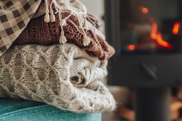 stack of warm clothes on an armchair an iron fireplace