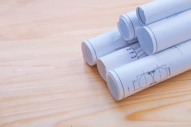 Stack of white bluprints on wooden board with copyspace horizontal version