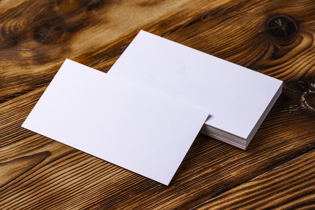 Stack of white business cards on brown wooden background