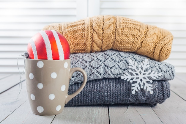 Photo stack of white cozy knitted sweaters on a wooden table