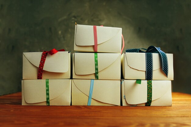 Stack of white gift boxes with ribbons on wooden table festive still life preparing for christmas co...