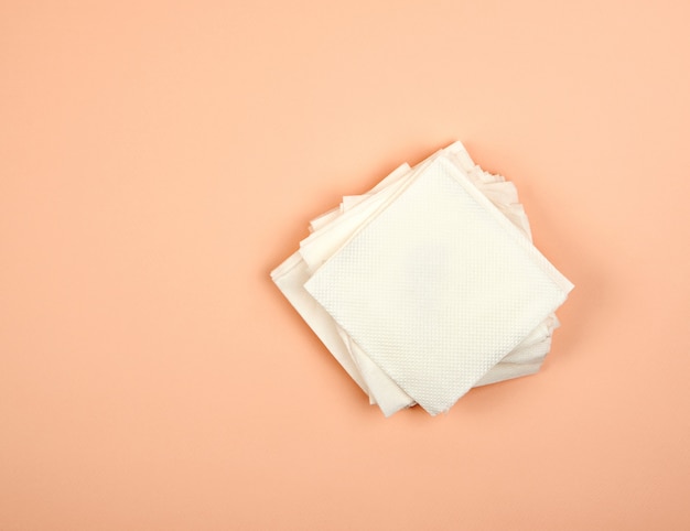 Stack of white paper napkins on beige 