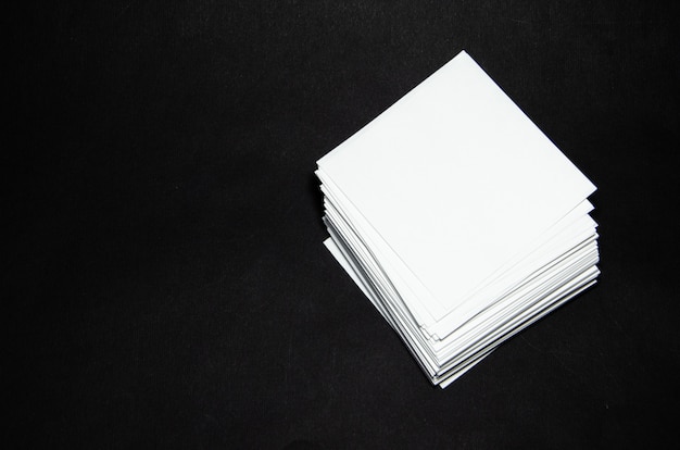 Stack of white paper small squares stickers on black