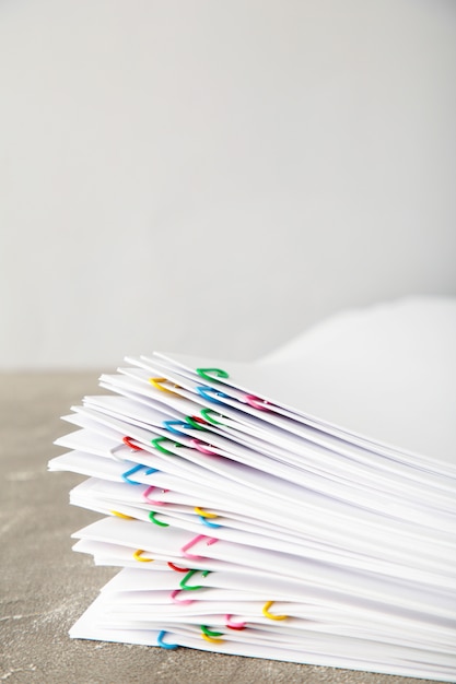 Stack of white paper with clips on grey