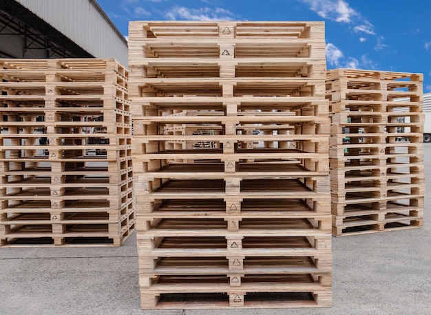 Foto pila di stoccaggio di pallet di legno al magazzino della fabbrica di produzione.