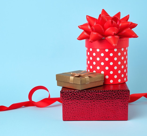 Photo stack of wrapped gifts with knotted bows on blue