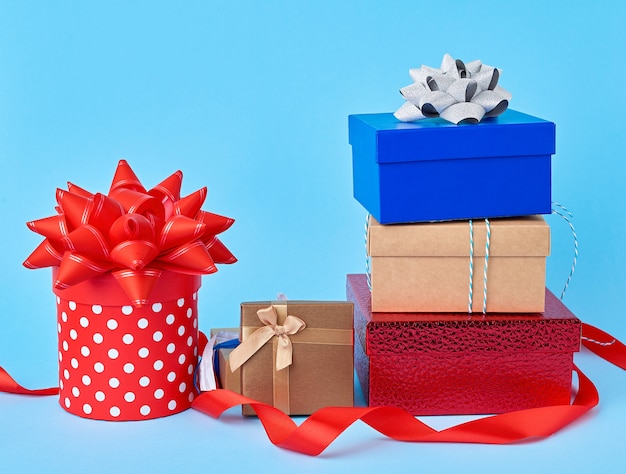 Stack of wrapped gifts with knotted bows on a blue 