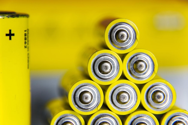 Stack of yellow AA batteries close up abstract coloured background