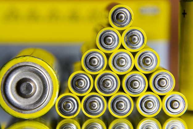 黄色の単三電池のスタックを抽象的な色付きの背景を閉じる