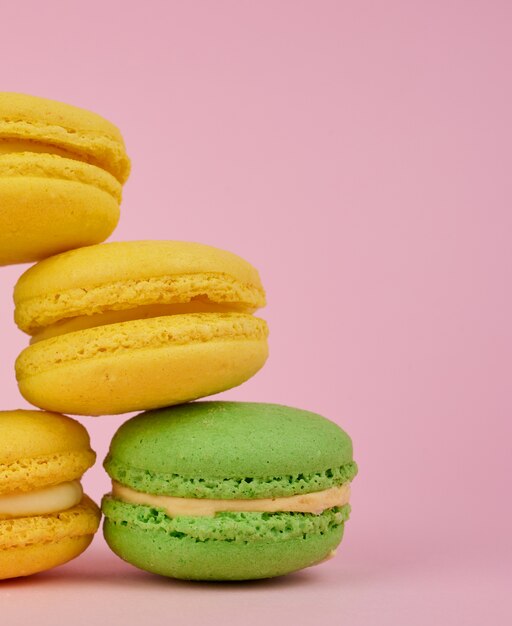 Stack of yellow and green round almond flour cakes macarons with cream