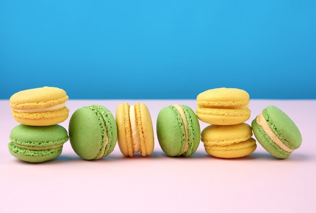 Stack of yellow and green round almond flour cakes macarons