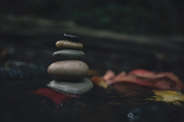 Stack of zen stones pebble rocks stacked on top of each other in stream in forest Zen like