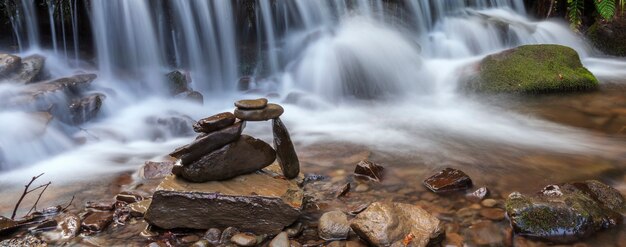 Stacked balanced rocks on mountain river waterfall