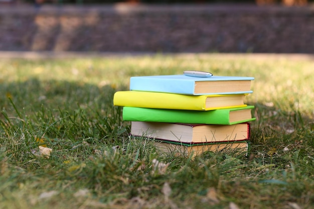 Stacked books in grass outside