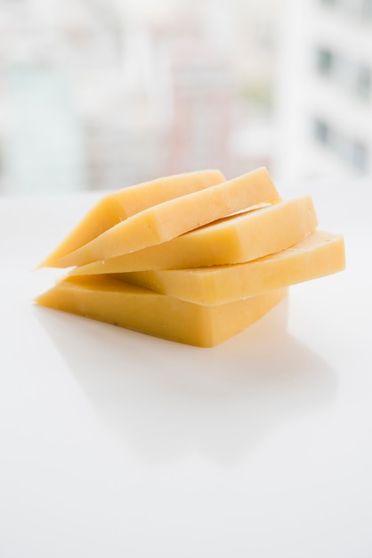 Photo stacked of cheese slices on white table