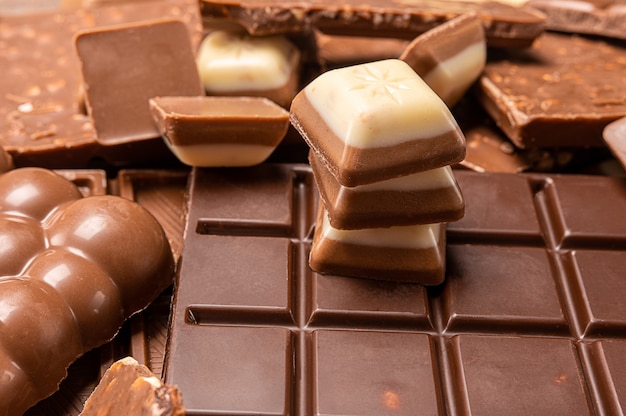 Stacked chocolate bars. dark and milk chocolates with nuts, assorted sweet bar. Chocolate bar pieces. Background with chocolate. Sweet food photo concept.