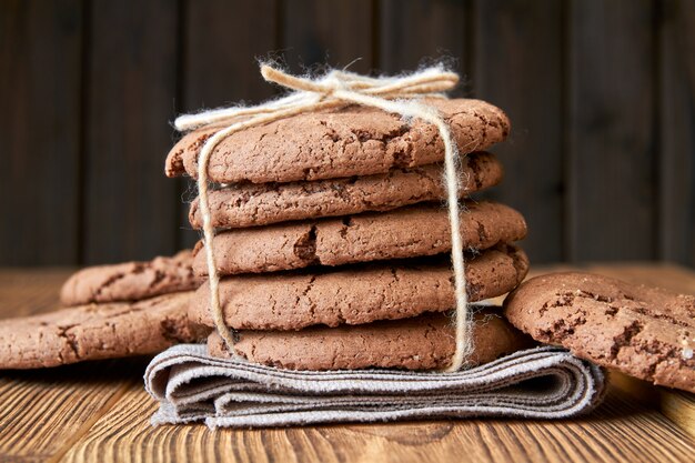 Stacked cookies on brown napkin and on wooden table