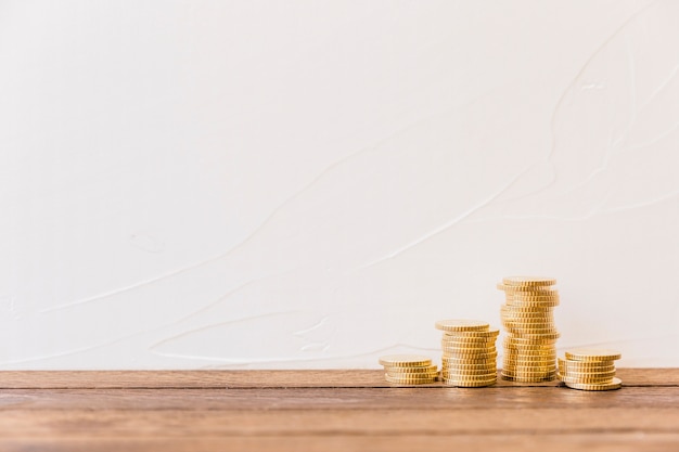 Photo stacked golden coins in front of wall