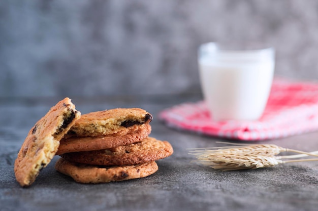 Stacked home made cookie view with a glass of milk and wheat spike studio shot