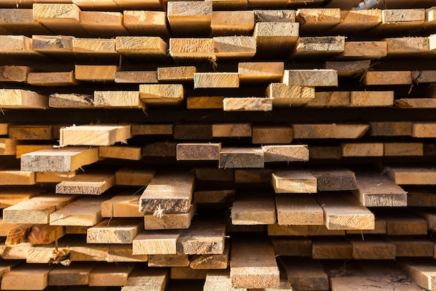 Stacked lumber background Folded wood Closeup cross section of board boards stick out from pile of lumber Lumber for use in construction