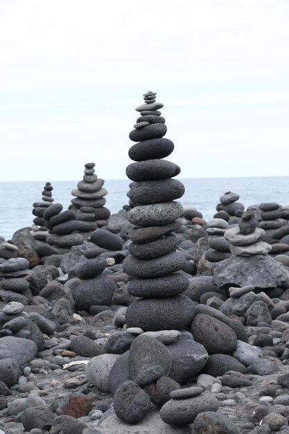 Photo stacked pebbles at beach against sky