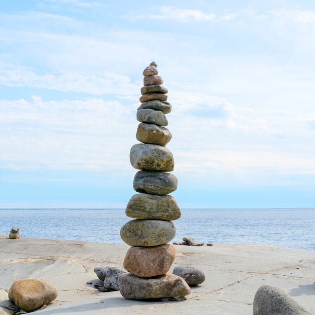 Stacked rocks che equilibra, impilando con precisione. torre di pietra sulla riva. copia spazio.