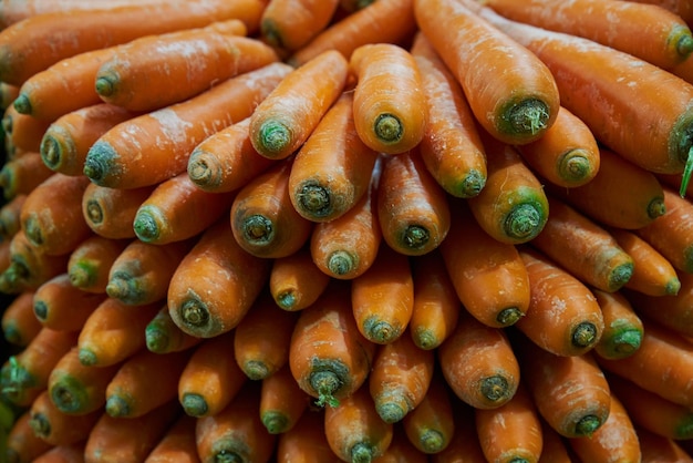 Stacked and sorted carrots placed on a shelf for sale at a market