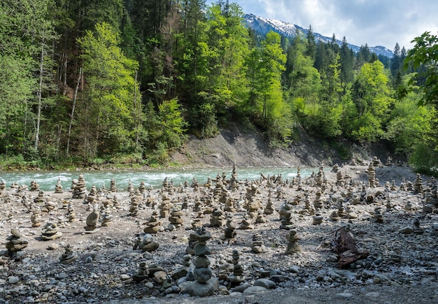 Foto pietre impilate sulla riva di un fiume nella foresta