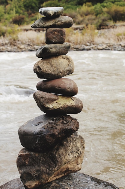 Photo stacked stones by river on rock