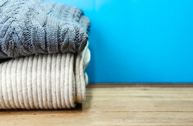 Stacked sweater with copy space on wooden table