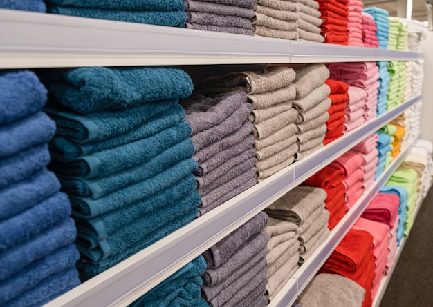 Сложенные полотенца в продаже в универмаге. Соберите полотенца в местном магазине. Банные полотенца в местном магазине.