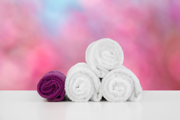 Stacked white spa towels on table against blurred background