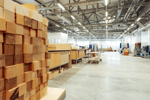 Stacked wooden bars in workshop of furniture manufacture