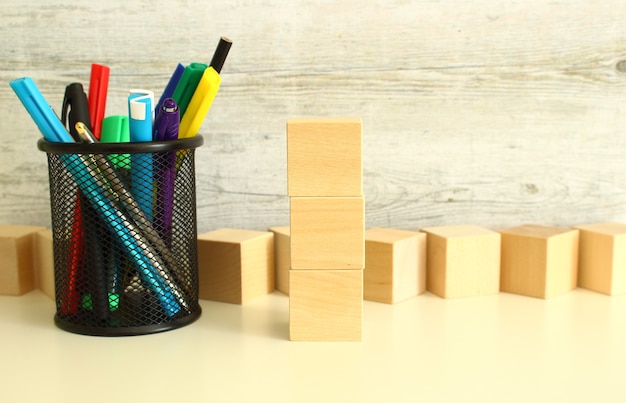 Stacked wooden cubes for letters on a white work table on a textured gray background. Business concept