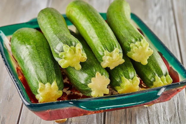 Stacked zucchini on plate on gray wooden background