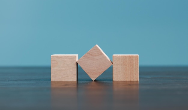 Stacking blank wooden cubes on blue background with copy space for input wording and infographic icon Empty brown wooden object block for symbol icon put technology zero gravity business concept