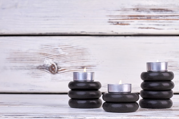 Stacks of black stones with burning candles still life