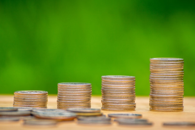 стопки монет на деревянный стол с зеленым фоном концепции экономии денег