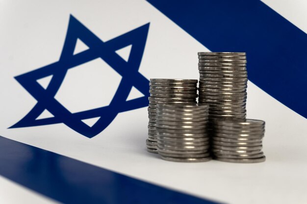 Photo stacks of coins on the background of israeli flag