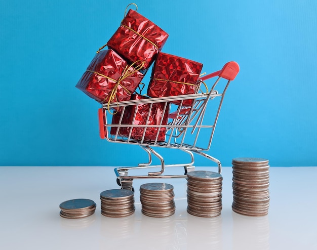 Stacks of coins and basket with gift boxes