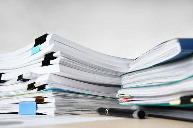 Stacks of documents on table against light background