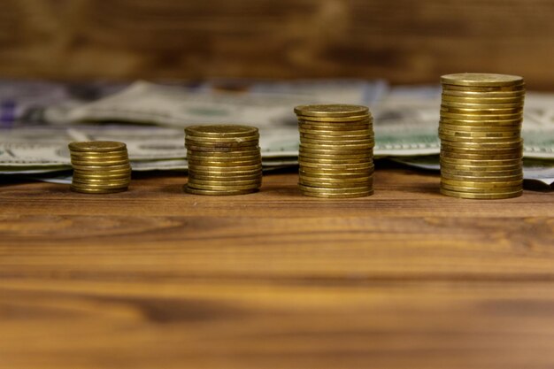 Photo stacks of golden coins and dollar bills on wooden background. business concept