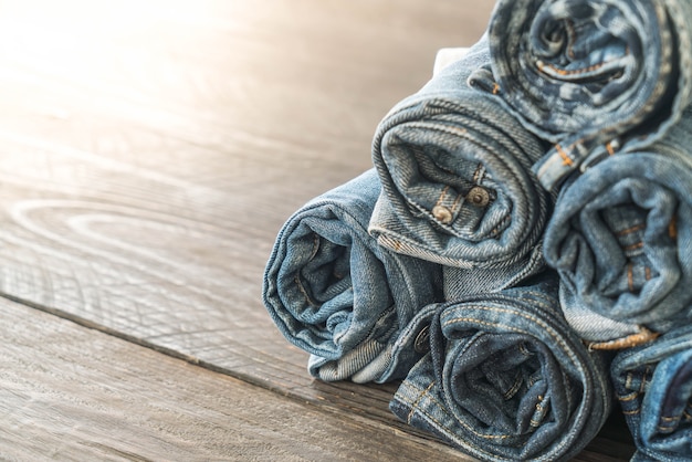 stacks of jeans clothing on wood 